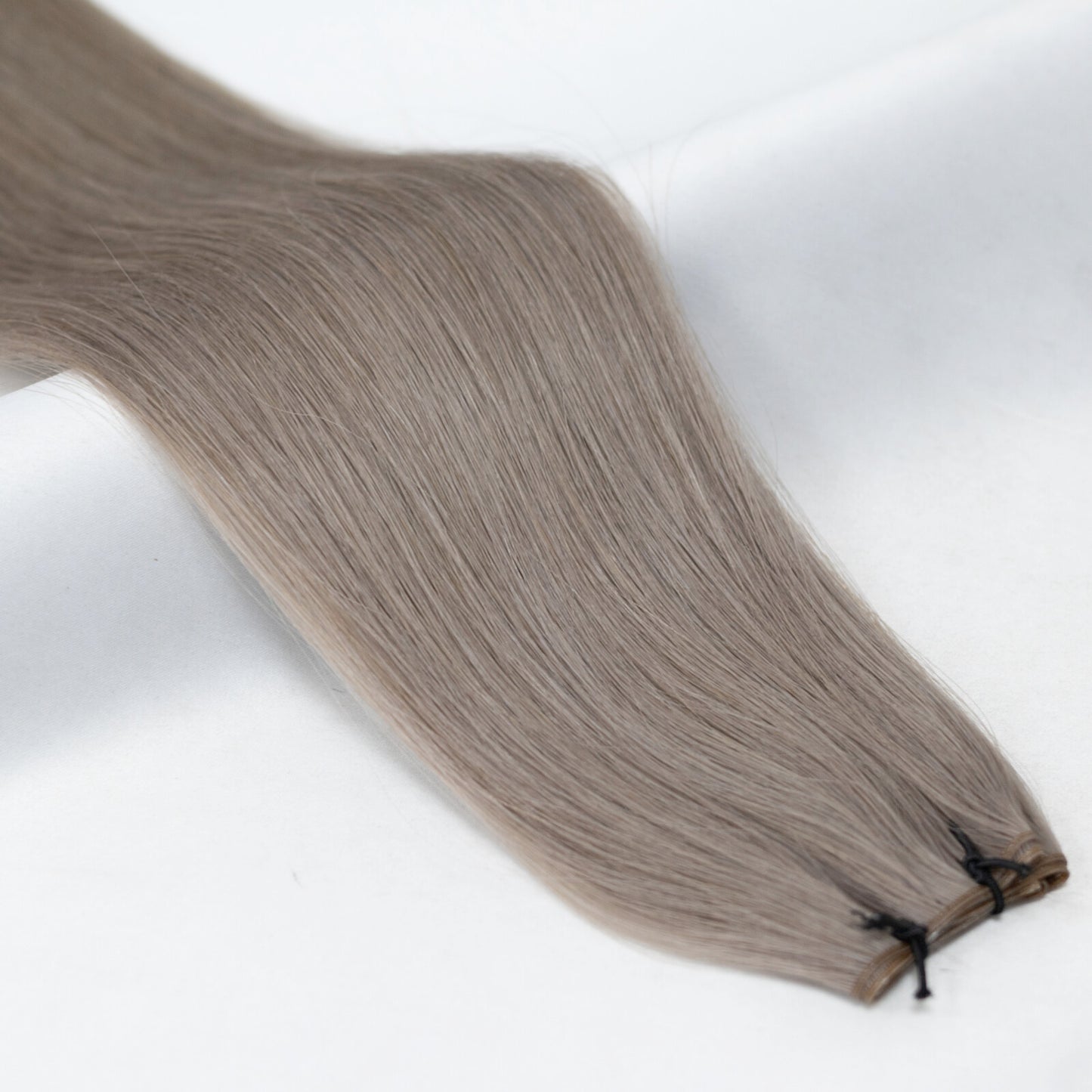 Soft ash blonde hair extensions with a cool, natural tone for a seamless blend. Available in Weft, Tape, Nano Tip, and Invisi Weft.