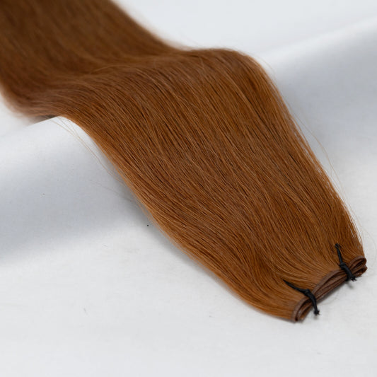 Reddish-brown auburn hair extensions for a bold yet natural look. Available in Weft, Tape, Nano Tip, and Invisi Weft.