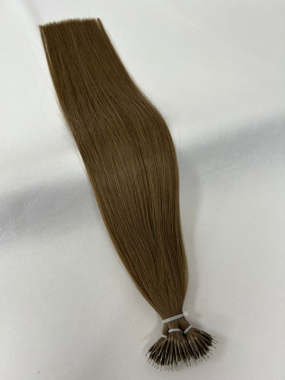 8 Ash Brown nano tip hair extensions featuring discreet nano tips for a smooth, lightweight fit. A cool-toned medium brown shade for effortless blending.