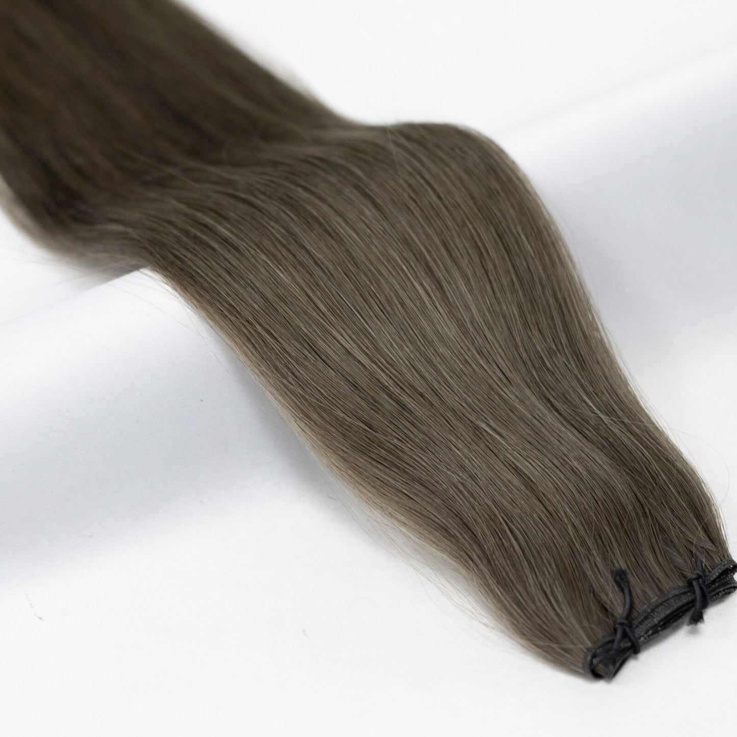 Medium brown hair extensions with warm ash undertones for a soft, natural finish. Available in Weft, Tape, Nano Tip, and Invisi Weft.