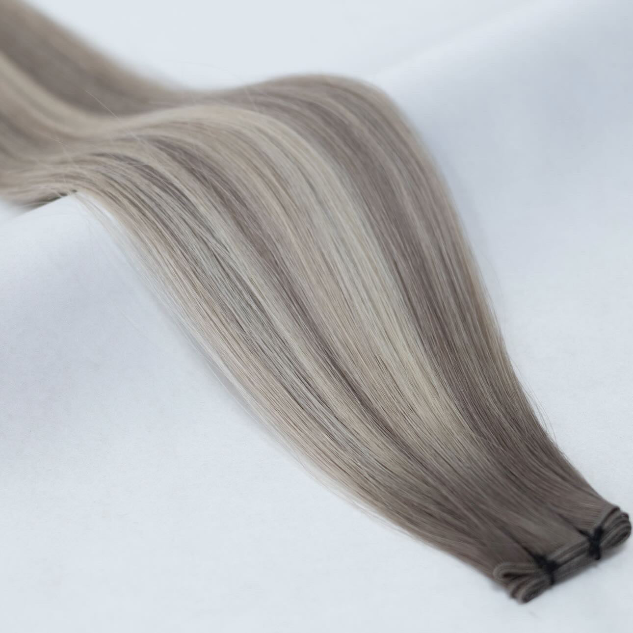 B18/60A balayage hair extensions featuring a seamless transition from warm blonde to platinum for a sun-kissed finish. Available in Weft, Tape, Nano Tip, and Invisi Weft.