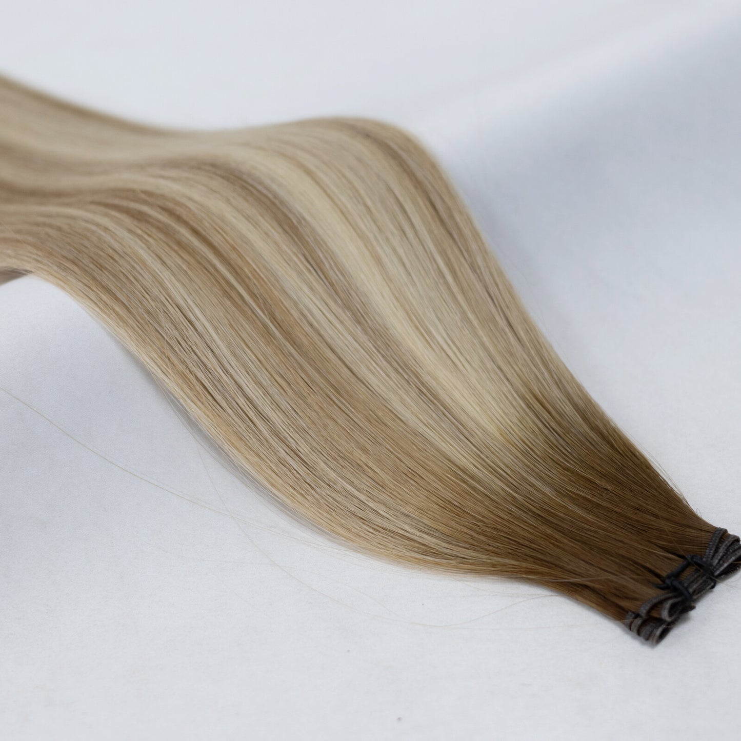 Natural balayage hair extensions blending warm brown, ash brown, and platinum blonde. Available in Weft, Tape, Nano Tip, and Invisi Weft.