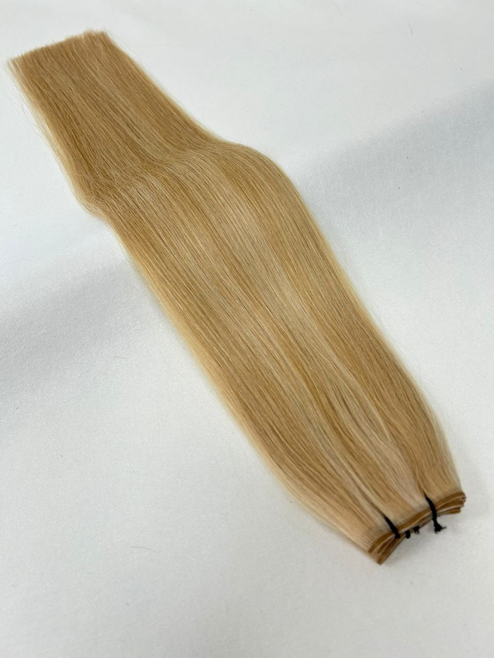 P27/60 hair extensions featuring a blend of warm blonde and platinum shades for a natural, dimensional look. Available in Weft, Tape, Nano Tip, and Invisi Weft.