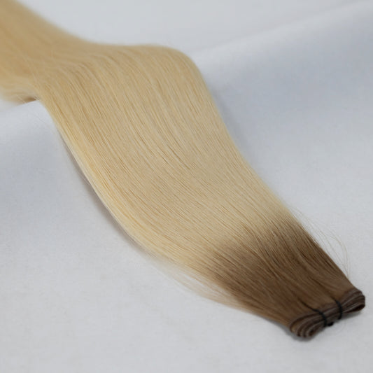 Ombre hair extensions transitioning from rich brown to bright platinum blonde. Available in Weft, Tape, Nano Tip, and Invisi Weft.