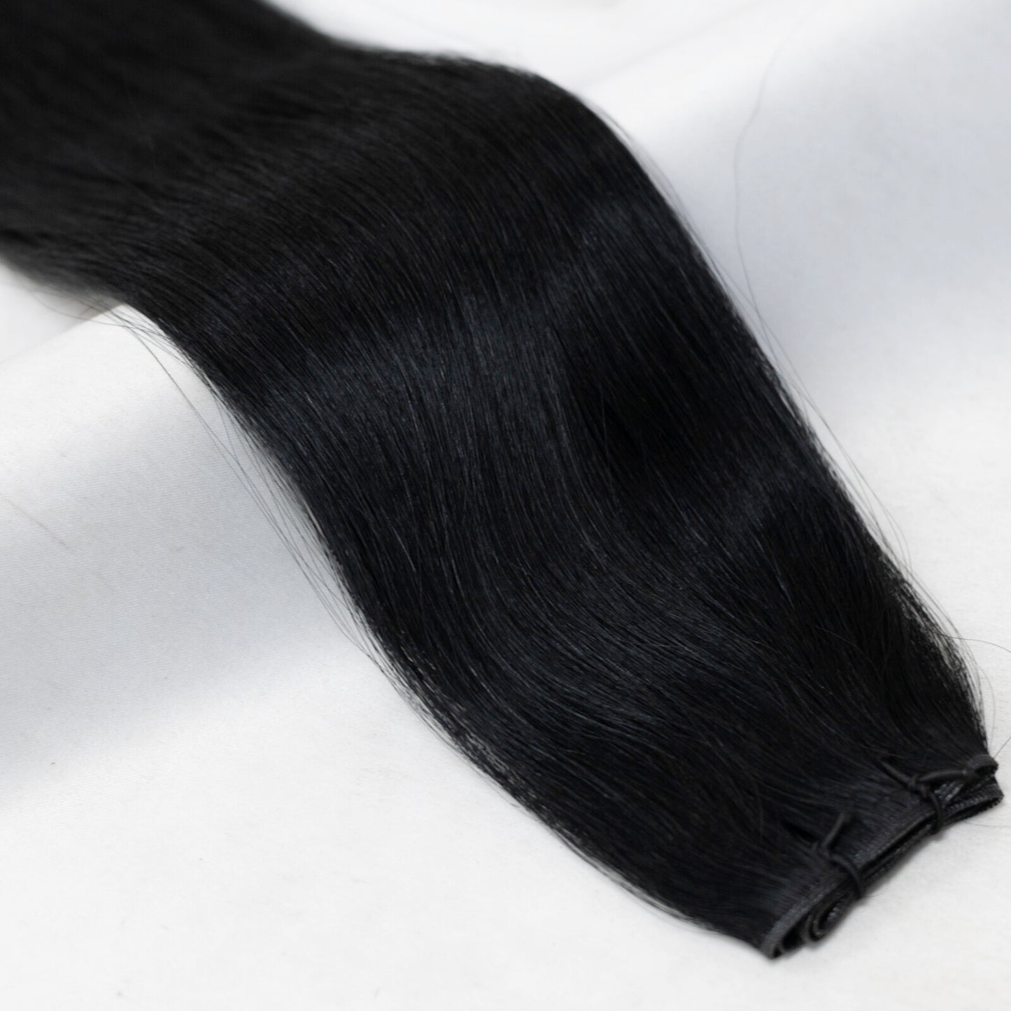 Premium jet black hair extensions from Mane Attraction, named after the founder Ebony. Available in Weft, Tape, Nano Tip, and Invisi Weft.
